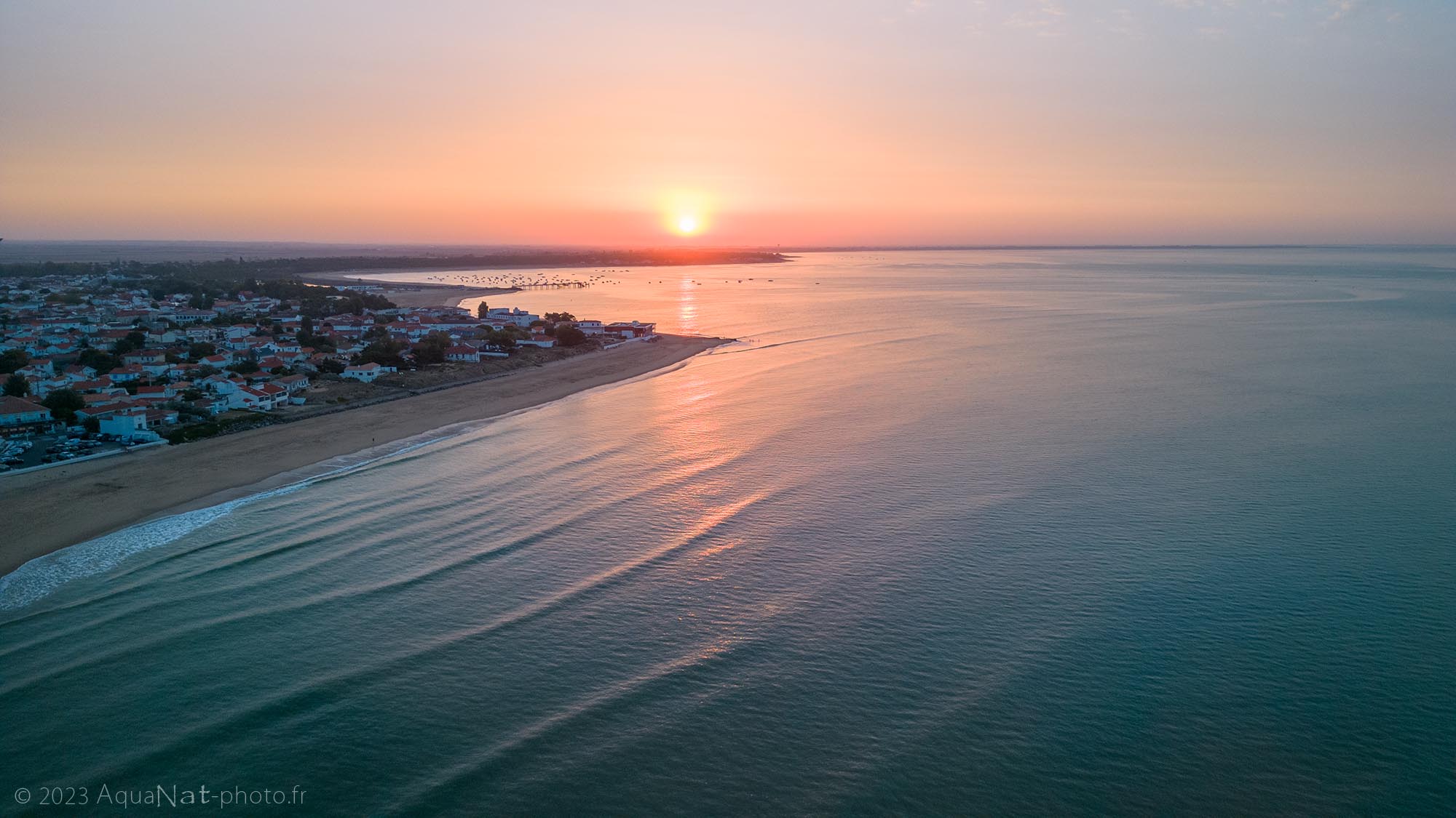 Vue aérienne du lever de soleil sur la baie de la Tranche sur mer aux couleurs pastels.