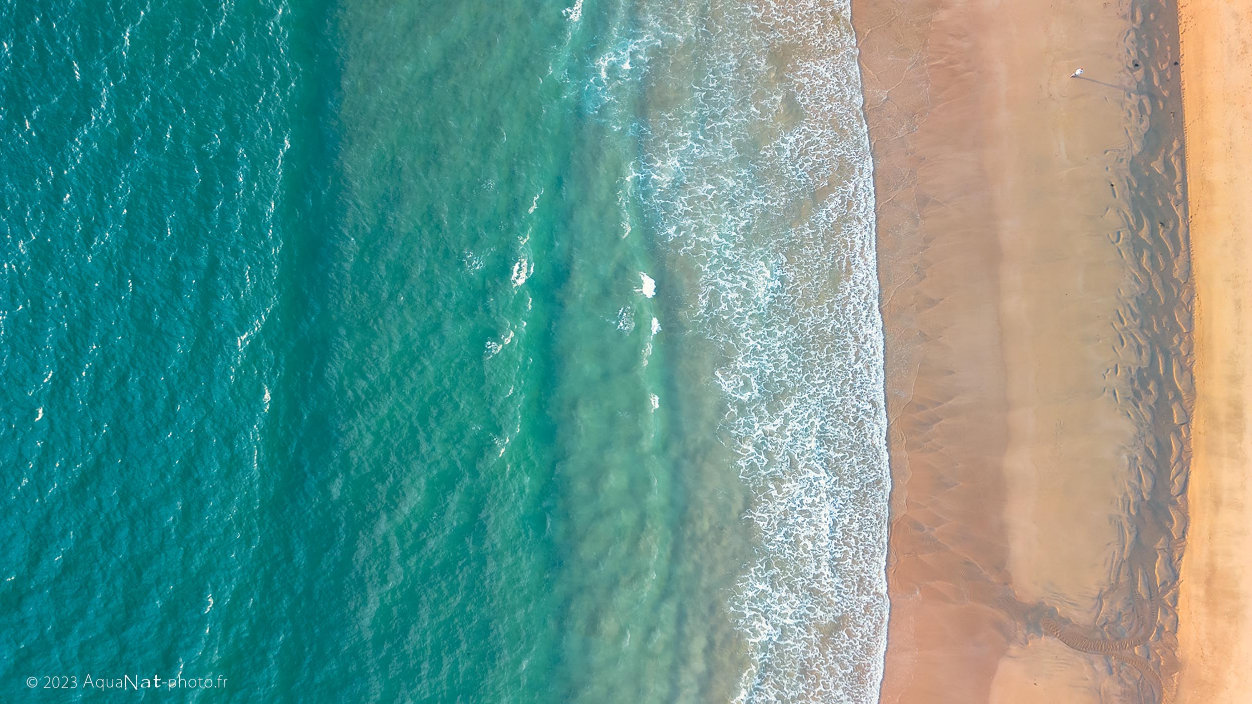 top down au drone sur le bord de plage eau turquoise et transparente de l'Atlantique